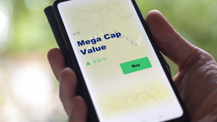 An investor's analyzing the MegaCap Value etf fund on screen. A phone shows the ETF's prices  to invest