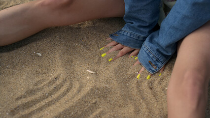 Unknown girl hands drawing lines on beach sand close up. Lady enjoy nature.