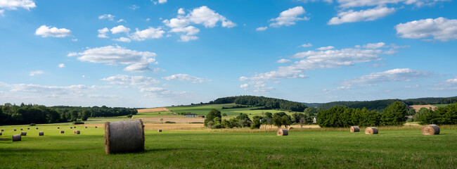 countryside landscape of belgian ardennes region near han sur lesse and rochefort with hay bales under blue sky - 524932761