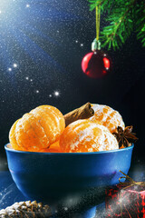 juicy tangerines in bowl with cinnamon and star anise tubes on the background of unfocused lights and snowflakes, festive Christmas or New Year design, close-up