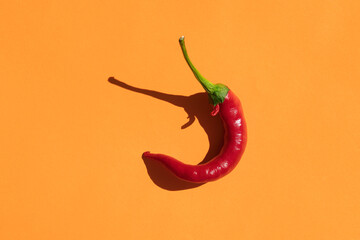 red hot pepper on a yellow background with a hard shadow