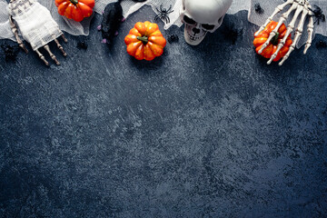 Halloween decorations, pumpkins, skull, zombie hands wrapped bandage on grave stone. Flat lay, top...