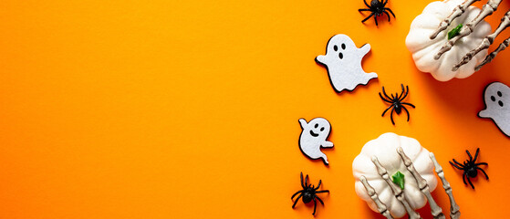 Happy Halloween holiday banner design. Ghosts, pumpkins ,spiders on orange background. Flat lay, top view, copy space.