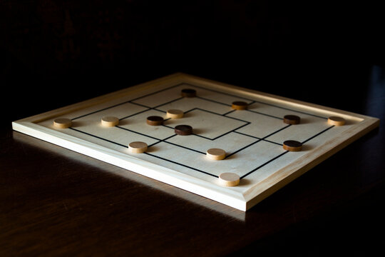 Playing mill game on a wooden table