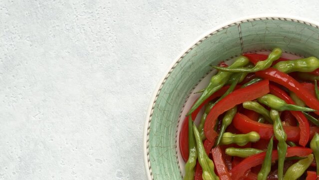 Stir-fry rat tail radish dish with red bell pepper on a plate. Vegan cuisine meal. Copy space.