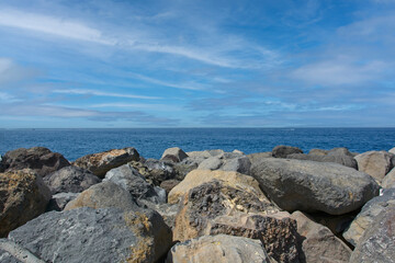 Fototapeta na wymiar Big stones in front of the open sea with blue sky