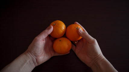 Oranges in hand. The man is holding and passing an orange. Photograph of citrus fruits. vitamins healthy food