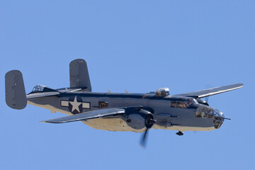 Fototapeta na wymiar Close view of a WWII era bomber (B-25 Mitchell) approaching in beautiful light 