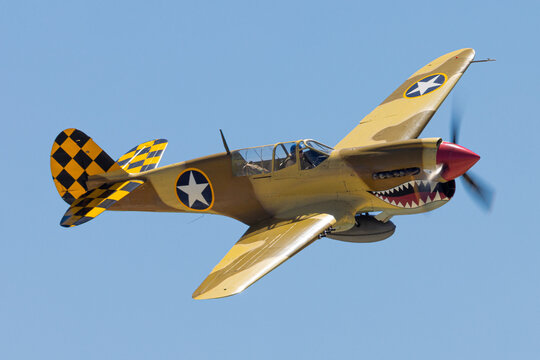 Extremely close view of a WWII fighter plane (P-40 Warhawk) against the sky, in epic light
