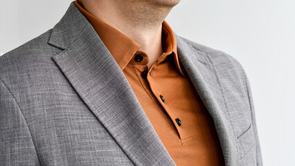 Fragment of grey jacket combined with fashionable beige shirt. Selective focus.
