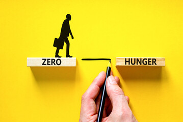 Zero hunger symbol. Concept words Zero hunger on wooden blocks on a beautiful yellow table yellow background. Businessman hand. Business, support and Zero hunger concept. Copy space. - obrazy, fototapety, plakaty