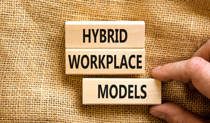 Hybrid workplace models symbol. Concept words Hybrid workplace models on wooden blocks. Businessman hand. Beautiful canvas background. Business hybrid workplace models quote concept. Copy space