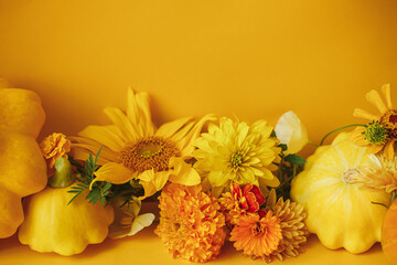 Happy Thanksgiving! Colorful flowers, pumpkin, pattypan squash composition on yellow background. Creative modern autumnal still life. Seasons greeting card template with space for text. Hello Fall