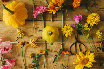 Autumn rustic composition. Colorful autumn flowers, pumpkins, pattypan squashes, scissors on wooden table flat lay. Harvest time in countryside, arranging flowers. Happy Thanksgiving! Hello Fall