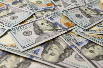 Money background. Texture of US dollars. Hundred dollar bills on the table close-up. Lots of American banknotes in cash. Profit, savings. Stack of dollars. Success, motivation, financial flows, wealth