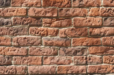 Large texture of a wall lined with red old bricks. Close-up.