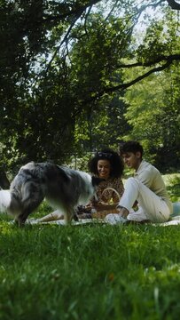 A couple on a date with a dog having a picnic