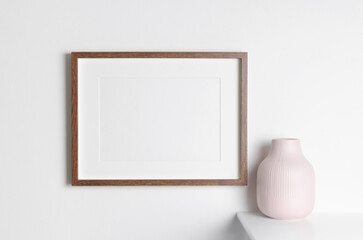 Wooden frame mockup with vase decoration on white wall, blank mockup with copy space