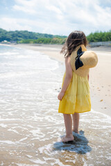 夏の海の砂浜で遊ぶ5歳の女の子