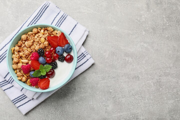 Flat lay composition with tasty granola and berries on light grey table. Space for text