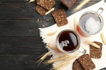 Mugs of delicious kvass, spikes and bread on wooden table, flat lay. Space for text - obrazy, fototapety, plakaty