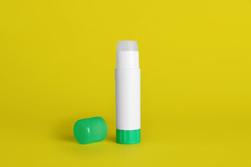 Blank glue stick and cap on yellow background