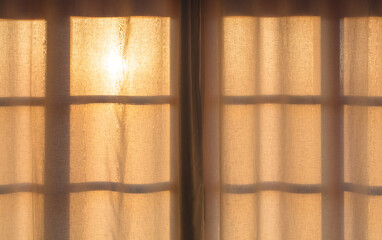 Sun behind the curtain on the window.