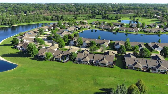 Aerial view of perfect, tidy condos around lake in summer.
