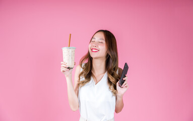 Asian woman girl drinking bubble milk tea excited emotion and holding smart phone, Food and drink delivery concept on the pink background