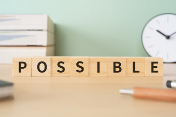 「POSSIBLE」と書かれたブロックが置かれたデスク

