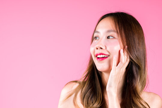 Eye tretment rejuvenation on her under eyes, Facial skin care makeup of Beauty attractive young asian woman applying concept on the pink backgound