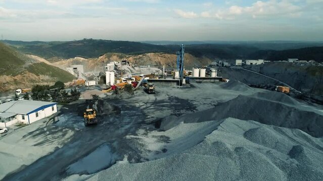 Aerial view of wheel loader working on construction site. Wheel bulldozer loading soil in scoop.