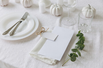 Fototapeta na wymiar Thanksgiving table setting, tableware and decorations. Blank white postcard on table mockup.