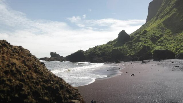 Vik, Iceland with black sand beach, rocks and the Atlantic Ocean with waves.