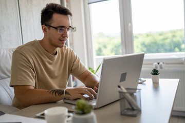 one man young adult caucasian male work on laptop computer in office