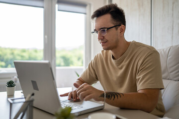 one man young adult caucasian male work on laptop computer in office