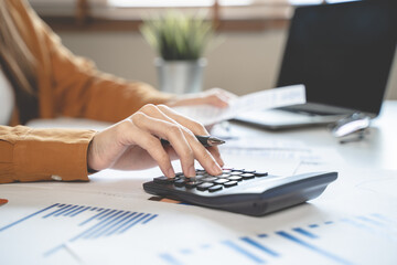 Fototapeta premium person using calculator calculating tax refund on the table