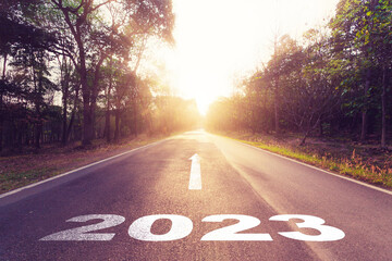 Empty asphalt road and New year 2023 concept. Driving on an empty road to Goals 2023 with sunset.