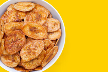 Banana chips on yellow background