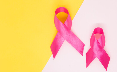 pink ribbon breast cancer awareness symbol isolated on white and yellow background