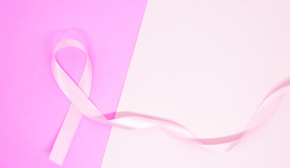 light pink ribbon breast cancer on pink paper background