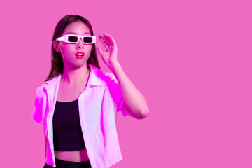 Surprised Young asian woman in black tank top and white shirt wearing sunglasses posing isolated pink color background with copy space