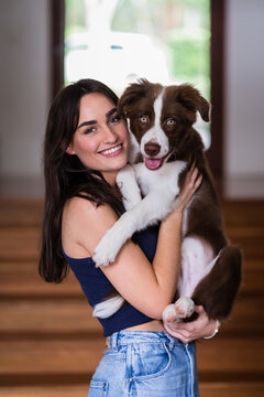 woman cuddling her border collie puppy