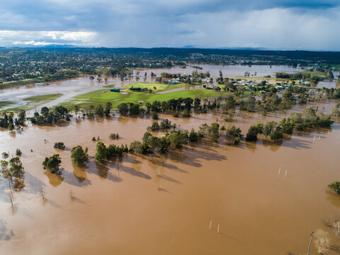 Patch of farmland paddock cut off by floodwater aerial view over flood and river