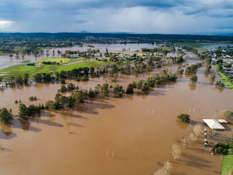Patch of farmland paddock cut off by floodwater aerial view over flood and river