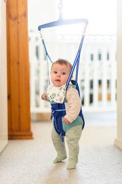 Baby playing in jolly jumper bouncing toy in doorway