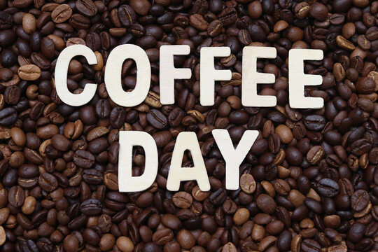 Coffee day word on roasted coffee beans background. Concept for cafe ,coffee shop ,business meeting ,office and drinking coffee beverage. 