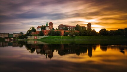 Zamek Królewski na Wawelu o wschodzie słońca ze złotym niebem w tle - obrazy, fototapety, plakaty