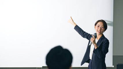 登壇する女性と聴衆　セミナー　プレゼンテーション