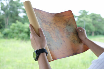 young man's hand holding a map travel to study travel routes around the world background Picture of...